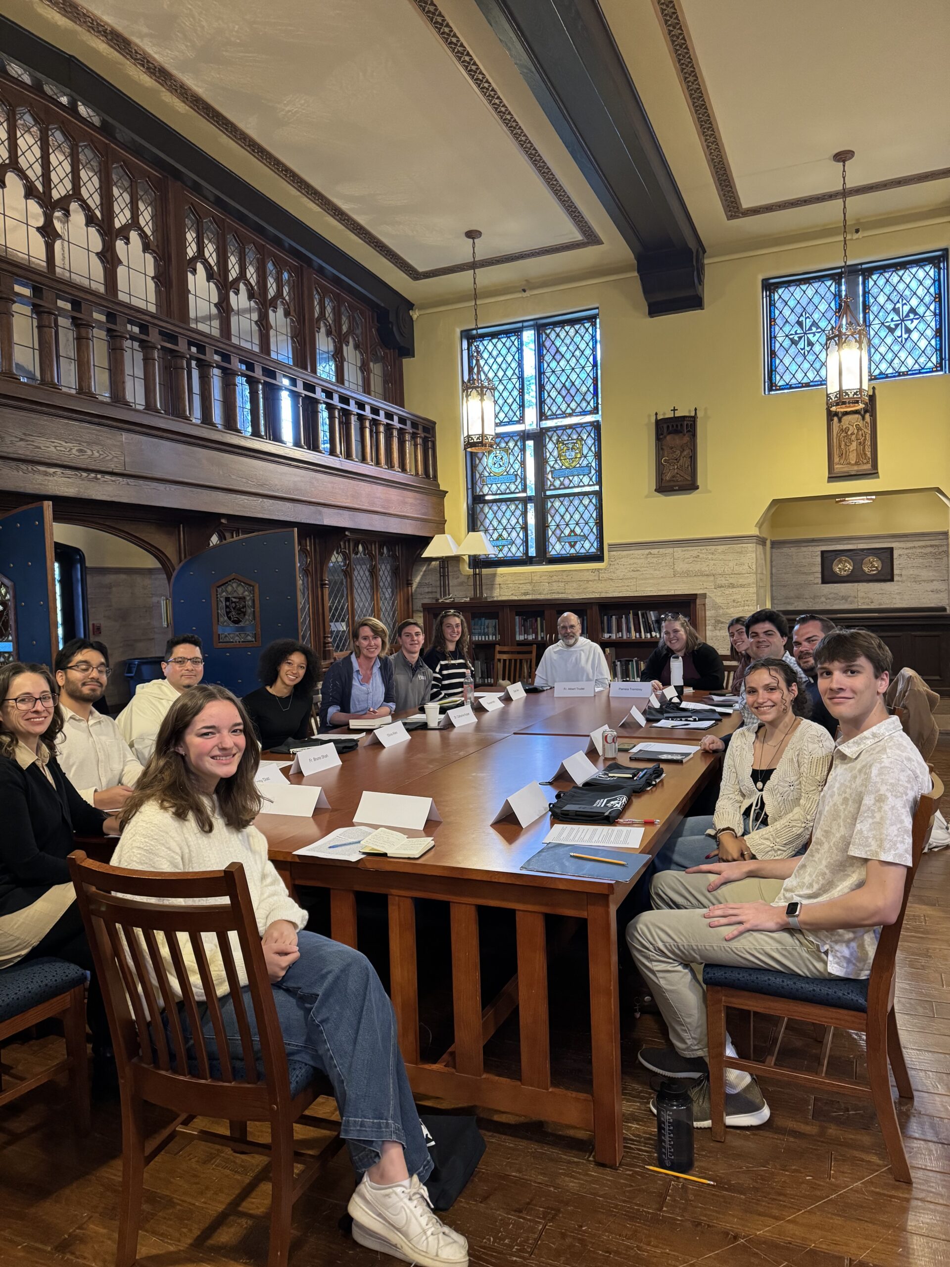 Picture of 15  Quinn Family Symposium participants sitting around a large table. 