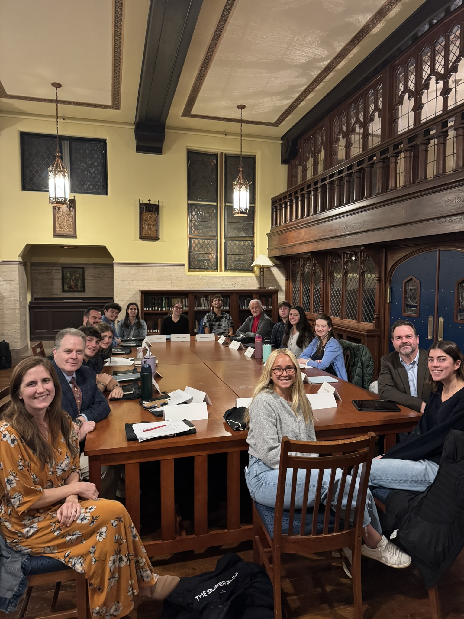 Group picture of Quinn Family Symposium participants sitting around a table